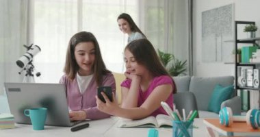 Cute girls doing homework and connecting online