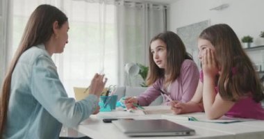 Woman helping children with their homework