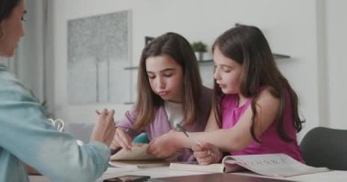 Woman helping children with their homework