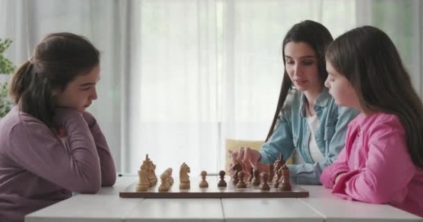 Young mother teaching chess to her daughters — 비디오