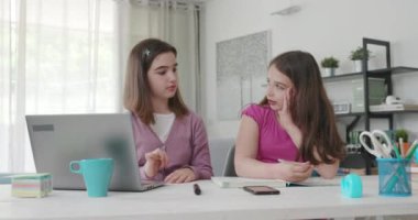 Girl helping her younger sister with her homework