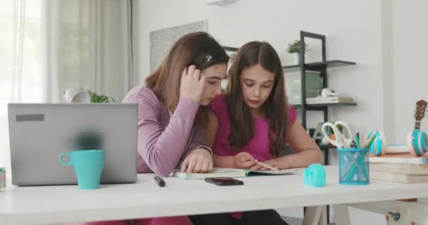 Girl helping her younger sister with her homework — Stock video