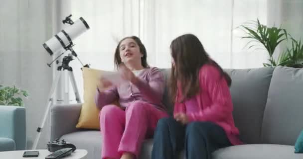 Cheerful girls sitting on the sofa and connecting with a tablet — Video
