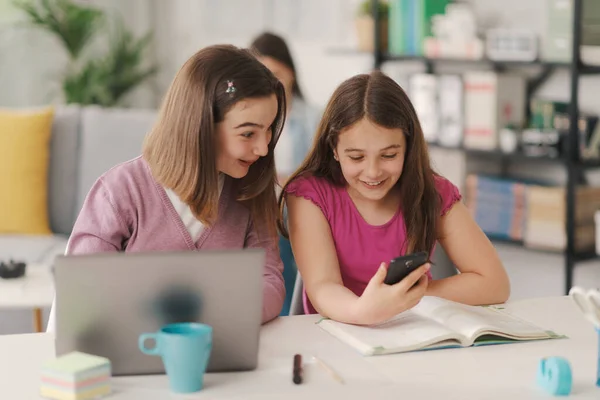 Happy Smiling Girls Sitting Desk Together Home One Showing Something — Stockfoto