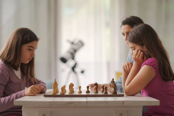 Girls Playing Chess Together Home Mother Sitting Next Them Watching — Foto Stock