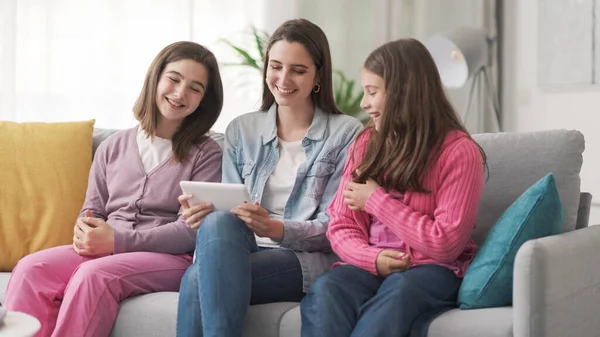 Happy Girls Sitting Sofa Connecting Digital Tablet Watching Movies Online — Fotografia de Stock