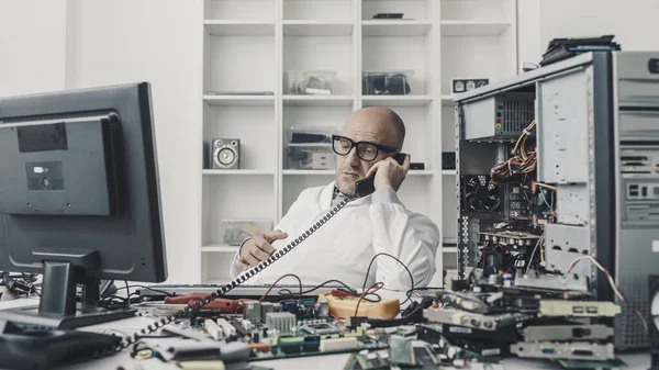 Distracted Technician Sitting Desk Talking Phone Instead Repairing Broken Computer — Stock Photo, Image