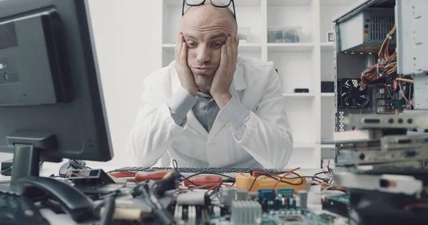 ストレスフレッシュされたコンピュータの修理技術者がオフィスの机に座って手で頭 — ストック写真