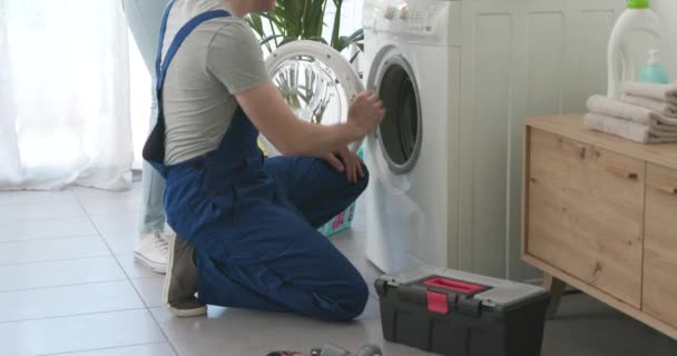 Técnico verificando uma máquina de lavar roupa quebrada — Vídeo de Stock