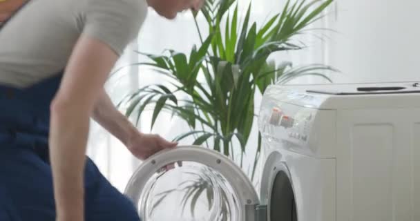 Técnico arreglando una lavadora rota — Vídeos de Stock
