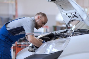 Profesyonel tamirci araba motoru ve araba tamir hizmeti konseptini kontrol ediyor.