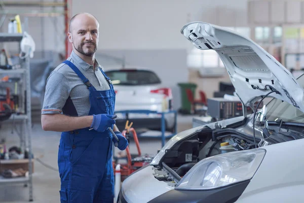 Pewny Siebie Mechanik Pozował Garażu Sprawdza Silnik Samochodu — Zdjęcie stockowe