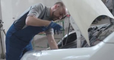 Profesyonel tamirci arabayı kontrol ediyor.