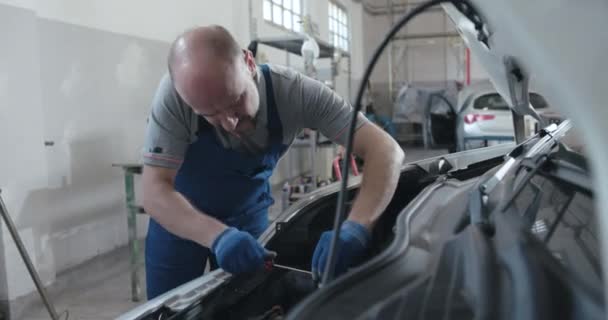 Mekanik memperbaiki mobil di bengkel — Stok Video