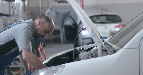 Meccanico professionista che ripara un'auto in garage — Video Stock