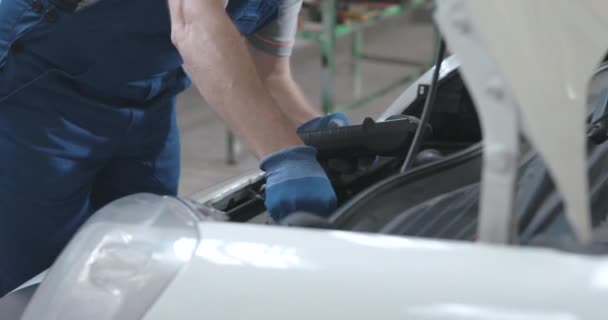 Professioneller Mechaniker testet Autobatterie mit einem Tester — Stockvideo