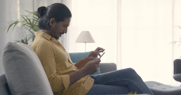 Bonito Homem Sentado Sofá Casa Conectando Com Tablet Digital Estilo — Fotografia de Stock