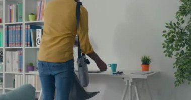 Adam işten sonra eve gelir ve kanepeye oturur.