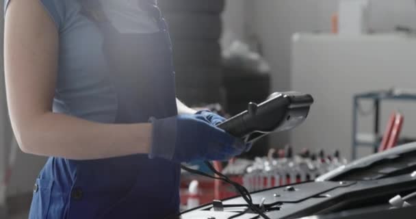 Mécanicien féminin testant une batterie de voiture — Video