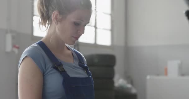 Mécanicien féminin testant une batterie de voiture — Video