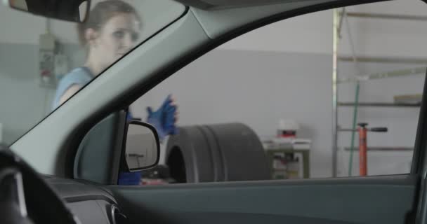 Mecánica sonriente apoyada en una ventana del coche — Vídeos de Stock