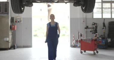 Araba altında çalışan profesyonel kadın tamirci.