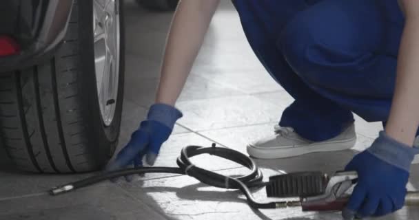 Kobieta mechanik sprawdza ciśnienie w oponach — Wideo stockowe