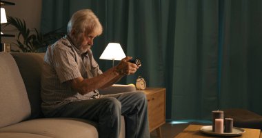 Evdeki kanepede oturan ve video oyunları, eğlence ve eğlence konsepti oynayan son sınıf öğrencisi.