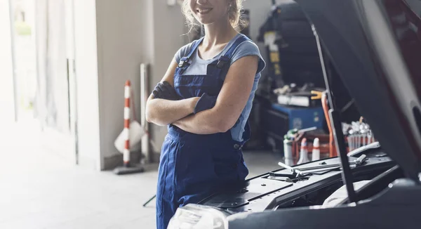 Sorridente Meccanico Femminile Posa Incrociata Accanto Auto Con Cappuccio Alzato — Foto Stock