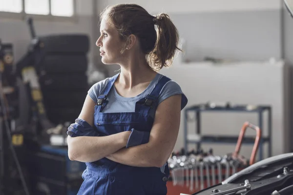 Portret Van Een Zelfverzekerde Vrouwelijke Monteur Poseren Auto Reparatiewerkplaats Kijkt — Stockfoto