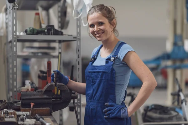 Garajda çalışan kendine güvenen profesyonel bir kadın tamirci.