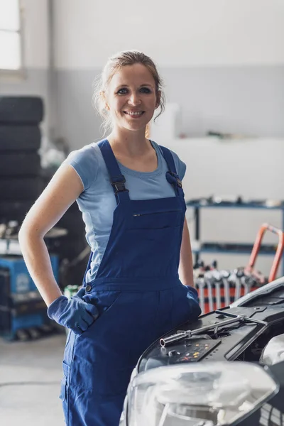 Selbstbewusst Lächelnde Mechanikerin Posiert Der Autowerkstatt Neben Einem Auto — Stockfoto