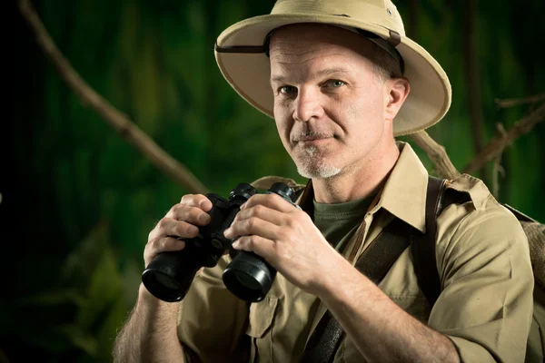 Adventurer in the jungle with binoculars — Stock Photo, Image