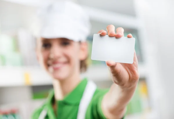 Escriturário de vendas segurando um cartão comercial em branco — Fotografia de Stock