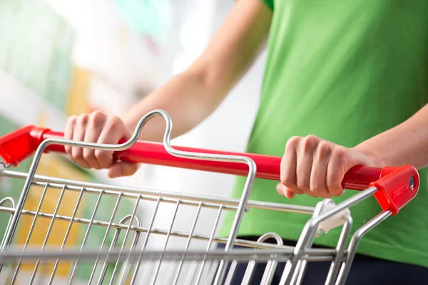 Vrouw met trolley koffer in supermarkt — Stockfoto