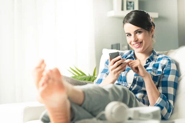 Frau nutzt Handy zu Hause — Stockfoto