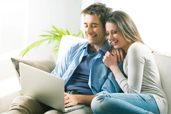 Casal relaxante no sofá com laptop — Fotografia de Stock