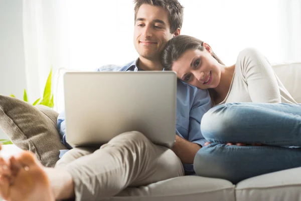 Paar ontspannen op de sofa met laptop — Stockfoto