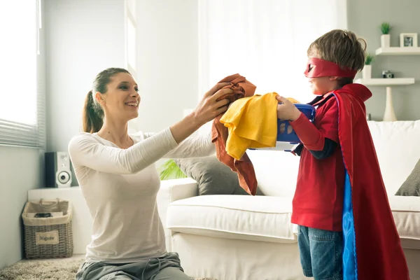 Pequeno super-herói ajudando sua mãe — Fotografia de Stock