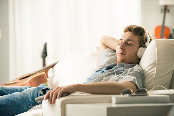 Guy with headphones on sofa — Stock Photo, Image