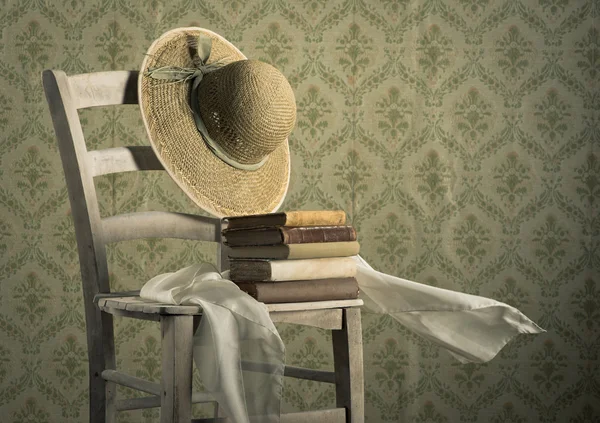 Libros antiguos en una silla con sombrero de paja — Foto de Stock