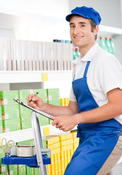 Sales clerk at work on a ladder — Stock Photo, Image