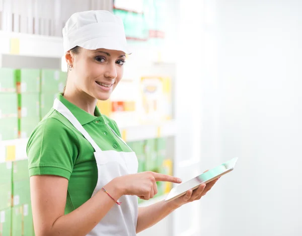 Verkäuferin mit Tablet im Supermarkt — Stockfoto