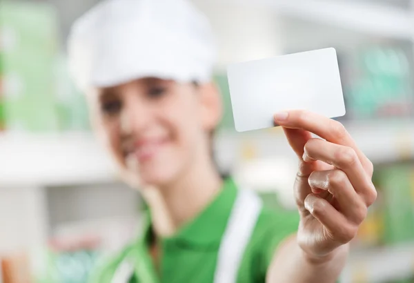 Sales clerk holding a blank business card — Stock Photo, Image