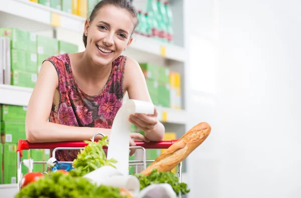 Femme vérifiant un reçu au supermarché — Photo