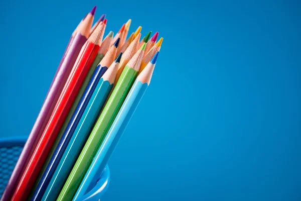 Crayons colorés sur fond bleu — Photo