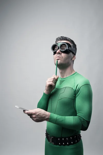 Superhero thinking with green pencil — Stock Photo, Image