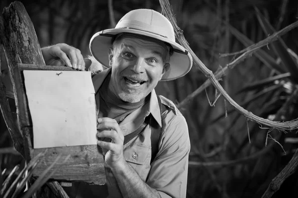 Explorador inclinado a firmar en el bosque — Foto de Stock