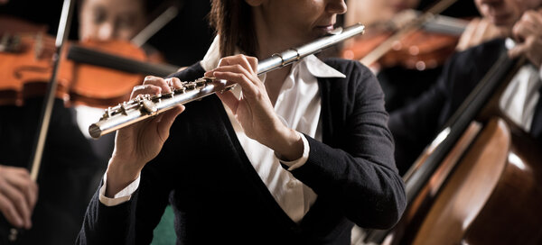 Flutist with symphony orchestra players