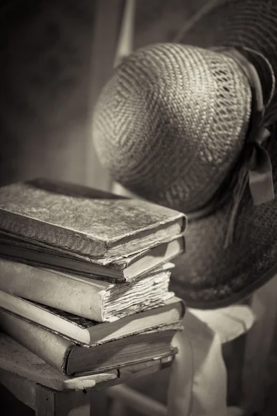 Pile of old books and straw hat — Stock Photo, Image